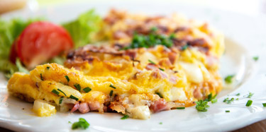Ham and cheese omelet on plate with lettuce and tomato