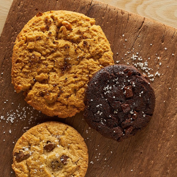Three cookies on a wooden board with salt sprinkles