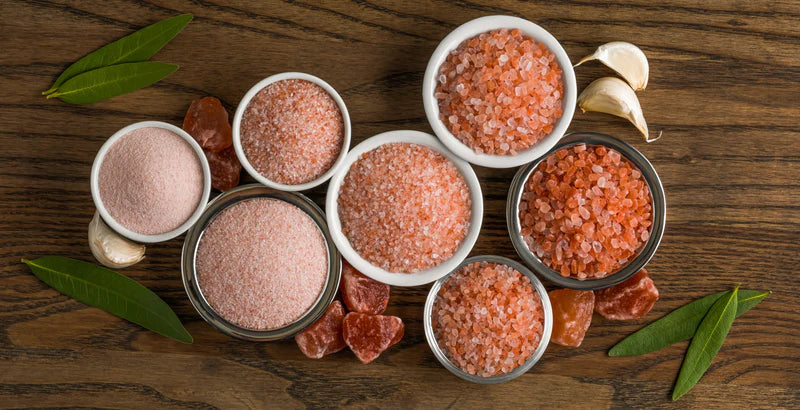 Bowls filled with Himalayan salt on wooden table