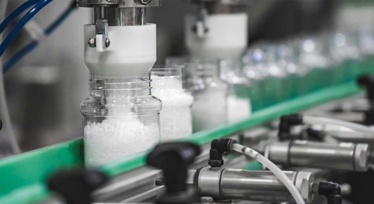 Jars of salt being filled by a machine