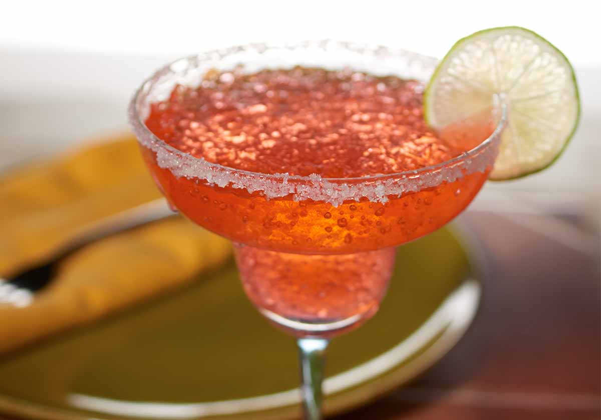 Pink margarita with salted rim and lime wedge