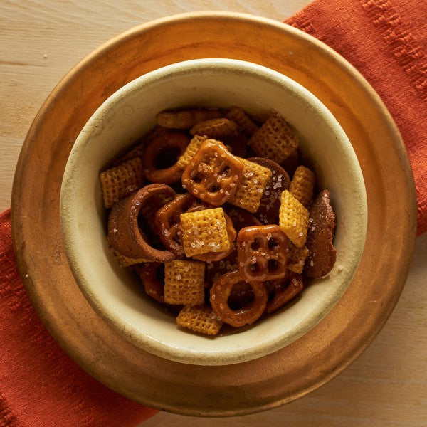 Snack mix in a bowl on a wooden surface